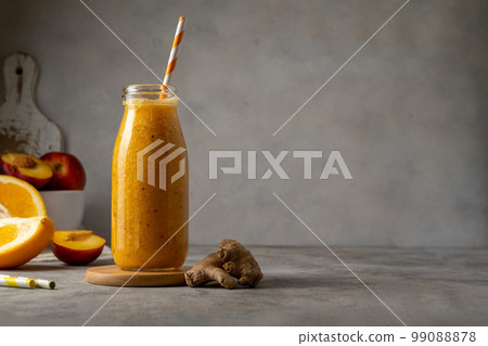 Bottle of fresh orange smoothie made with peach, ginger and orange, copy space Bottle of fresh orange smoothie made with peach, ginger and orange, copy space 99088878