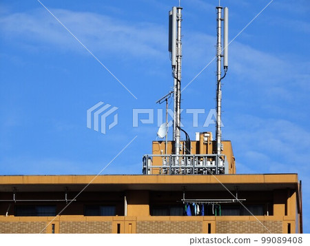 Mobile antenna base station on the roof of an apartment building Mobile antenna base station on the roof of an apartment building 99089408