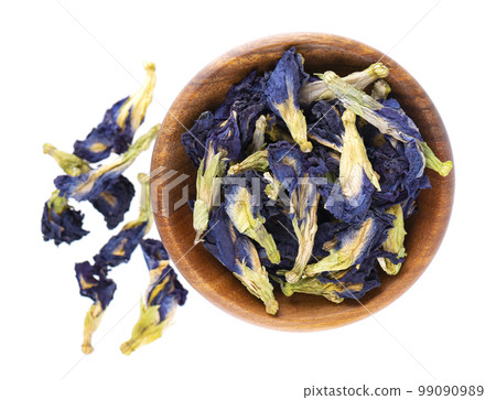 Butterfly pea flowers in wooden bowl, isolated on white background. Blue herbal tea. Clitoria Ternatea. Top view. Butterfly pea flowers in wooden bowl, isolated on white background. Blue herbal tea. Clitoria Ternatea. Top view. 99090989