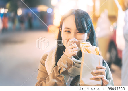Young adult asian woman holding japanese sweet at outdoor travel street food on winter Young adult asian woman holding japanese sweet at outdoor travel street food on winter 99093233
