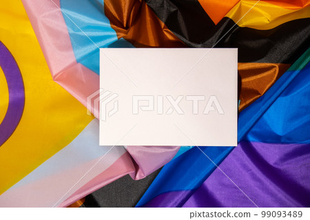 Empty paper blank on Rainbow LGBTQIA flag made from silk material. Mock up template copy space for your text. Symbol of LGBTQ pride month. Equal rights. Peace and freedom. Support LGBTQIA community Empty paper blank on Rainbow LGBTQIA flag made from silk material. Mock up template copy space for your text. Symbol of LGBTQ pride month. Equal rights. Peace and freedom. Support LGBTQIA community 99093489