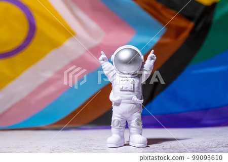Toy astronaut on Rainbow LGBTQIA flag made from silk material background. Happy pride month. Symbol of LGBTQ pride month. Equal rights. Peace and freedom. Support LGBTQIA community Toy astronaut on Rainbow LGBTQIA flag made from silk material background. Happy pride month. Symbol of LGBTQ pride month. Equal rights. Peace and freedom. Support LGBTQIA community 99093610
