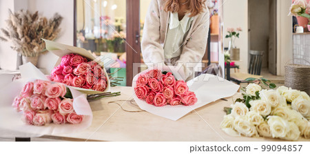Florist at work. Summer bouquet of roses. Learning flower arranging, making beautiful bouquets with your own hands. Flowers delivery Florist at work. Summer bouquet of roses. Learning flower arranging, making beautiful bouquets with your own hands. Flowers delivery 99094857