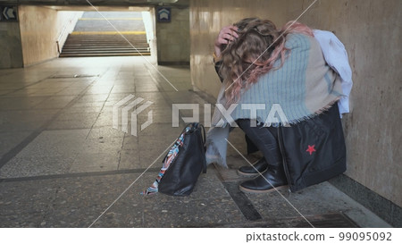 A lonely, sad girl sitting in an underpass. A lonely, sad girl sitting in an underpass. 99095092