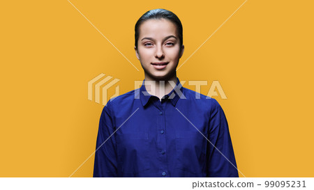 Portrait of smiling teenage girl 15, 16 years old on yellow background Portrait of smiling teenage girl 15, 16 years old on yellow background 99095231