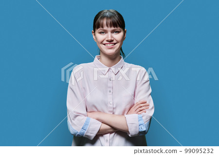Portrait of confident female student with arms crossed on blue background Portrait of confident female student with arms crossed on blue background 99095232