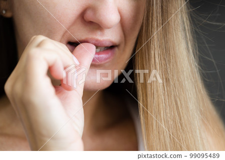 Young woman biting her fingernails. Closeup, selective focus. Nervous breakdown. Young woman biting her fingernails. Closeup, selective focus. Nervous breakdown. 99095489