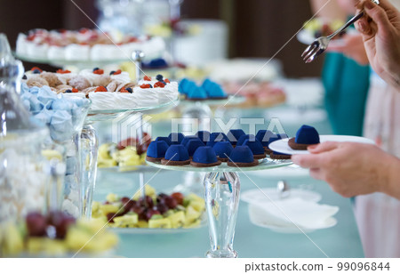 Women's hands taking sweets Women's hands taking sweets 99096844