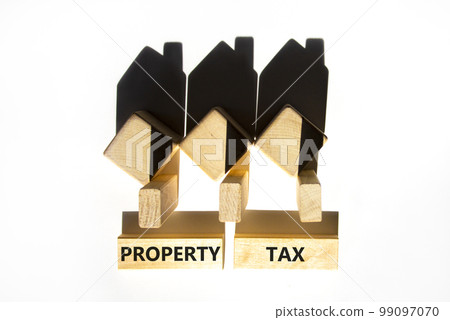 Property tax symbol. Concept words Property tax on wooden blocks. Beautiful white table white background. House model from wooden blocks and shadow. Business and property tax concept. Copy space. Property tax symbol. Concept words Property tax on wooden blocks. Beautiful white table white background. House model from wooden blocks and shadow. Business and property tax concept. Copy space. 99097070