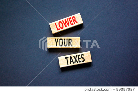 Lower your taxes symbol. Concept words Lower your taxes on wooden blocks on a beautiful black table black background. Business tax lower your taxes concept. Copy space. 99097087