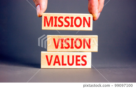 Mission vision values symbol. Concept words Mission Vision Values on wooden blocks on a beautiful grey table grey background. Businessman hand. Business mission vision values concept. Copy space. Mission vision values symbol. Concept words Mission Vision Values on wooden blocks on a beautiful grey table grey background. Businessman hand. Business mission vision values concept. Copy space. 99097100