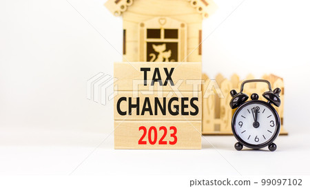Tax changes 2023 symbol. Concept words Tax changes 2023 on wooden blocks on a beautiful white table white background. Black alarm clock, house model. Business Tax changes 2023 concept. Copy space. Tax changes 2023 symbol. Concept words Tax changes 2023 on wooden blocks on a beautiful white table white background. Black alarm clock, house model. Business Tax changes 2023 concept. Copy space. 99097102