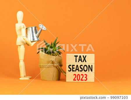 Tax season 2023 symbol. Concept words Tax season 2023 on wooden blocks on a beautiful orange table orange background. Businessman icon. Business Tax season 2023 concept. Copy space. Tax season 2023 symbol. Concept words Tax season 2023 on wooden blocks on a beautiful orange table orange background. Businessman icon. Business Tax season 2023 concept. Copy space. 99097103