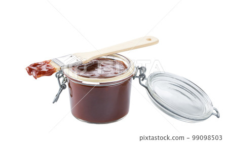 Barbecue sauce in a jar with barbecue brush isolated on a white background. Barbecue sauce in a jar with barbecue brush isolated on a white background. 99098503