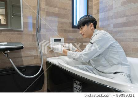 一名工人正在檢查浴室的浴缸 一名工人正在檢查浴室的浴缸 99099321