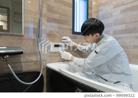 A worker inspecting the bathtub in the bathroom A worker inspecting the bathtub in the bathroom 99099322