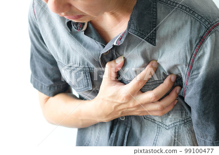 Man is sick and in pain and uses his hands to squeeze his chest He had chest pain caused by an acute heart attack. medical and health concepts 99100477