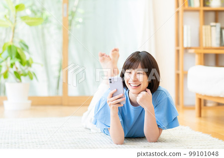 在客廳使用智能手機的年輕女性 99101048