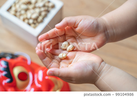 A child's hand receiving lucky beans for the number of years old A child's hand receiving lucky beans for the number of years old 99104986