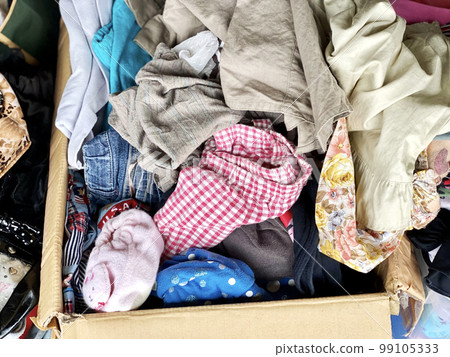 A lot of old clothes in a cardboard box 99105333