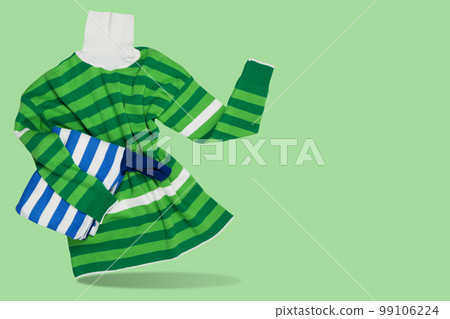Women's sweater, with green stripes, as if holding a folded sweater, the other hand points to the side, concept Women's sweater, with green stripes, as if holding a folded sweater, the other hand points to the side, concept 99106224