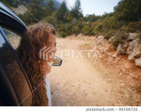 Woman on road trip traveling by rental car 99106726