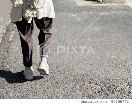 The feet of an elderly woman who walks with her hands behind her back The feet of an elderly woman who walks with her hands behind her back 99106762