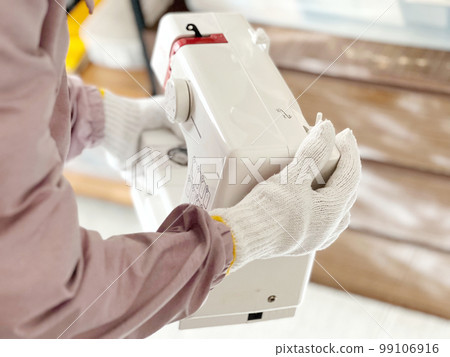 帶工作手套的手拿著縫紉機 帶工作手套的手拿著縫紉機 99106916