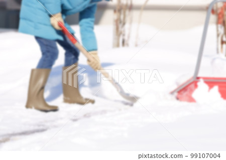 Middle-aged woman shoveling snow Faceless blurred image photo 99107004