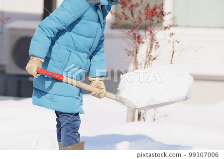 Middle-aged woman shoveling snow 99107006