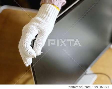 Gloved hand holding a monitor 99107075