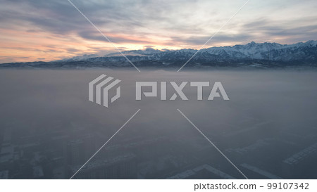 Dawn over the city in fog and smog. Mountain view Dawn over the city in fog and smog. Mountain view 99107342