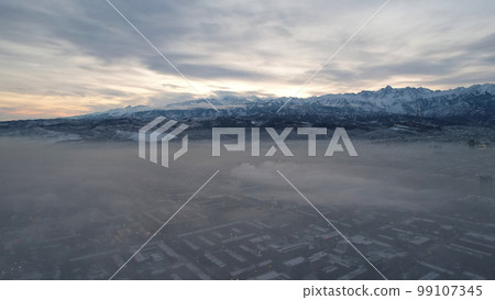 Dawn over the city in fog and smog. Mountain view 99107345
