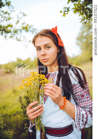 Photo of a smiling young woman in ethnic ukrainian shirt 99107822