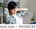 A young woman stretching on the sofa, relaxing, resting, refreshing, gymnastics 99108149