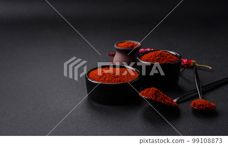 Spice smoked paprika in the form of powder in bowls and spoons Spice smoked paprika in the form of powder in bowls and spoons 99108873