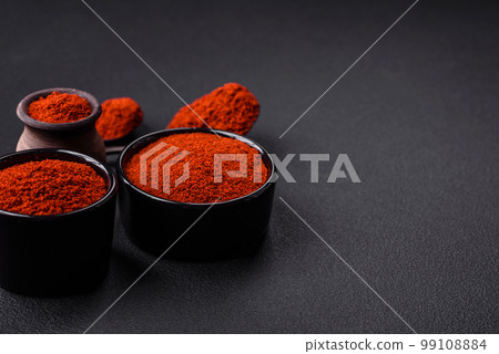 Spice smoked paprika in the form of powder in bowls and spoons 99108884