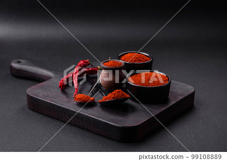 Spice smoked paprika in the form of powder in bowls and spoons 99108889