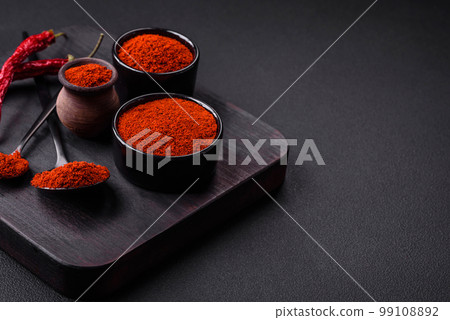 Spice smoked paprika in the form of powder in bowls and spoons 99108892