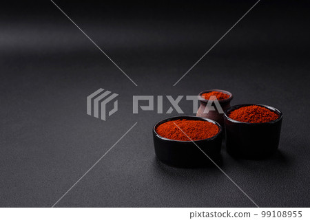 Spice smoked paprika in the form of powder in bowls and spoons 99108955