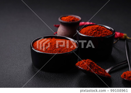 Spice smoked paprika in the form of powder in bowls and spoons 99108961