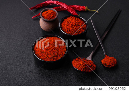 Spice smoked paprika in the form of powder in bowls and spoons 99108962