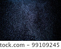 Organic dust particles floating on a colorful light beam on black background. 99109245