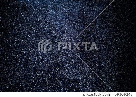 Organic dust particles floating on a colorful light beam on black background. Organic dust particles floating on a colorful light beam on black background. 99109245