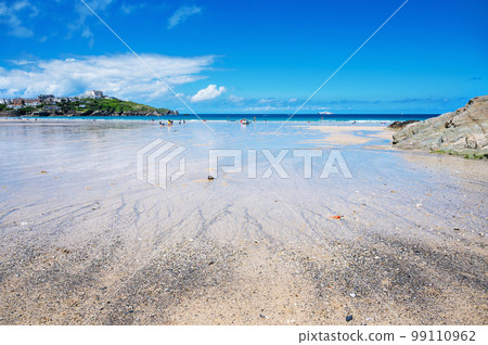 Beautiful Newquay beach with blue sea, stone cliffs and white sand in Cornwall, south west England, selective focus Beautiful Newquay beach with blue sea, stone cliffs and white sand in Cornwall, south west England, selective focus 99110962
