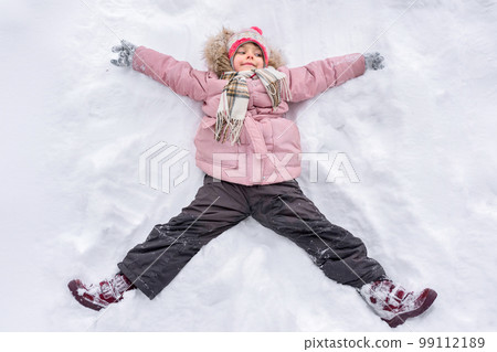 Little girl making snow angel outdoors in winter. Winter vacation and holidays Little girl making snow angel outdoors in winter. Winter vacation and holidays 99112189