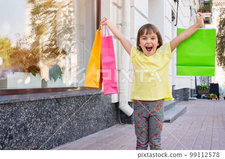 The happy child with purchases on the street 99112578