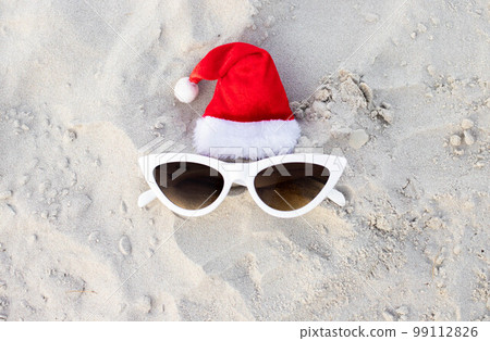 Santa Claus hat on the beach with sunglases Santa Claus hat on the beach with sunglases 99112826