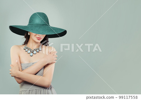 Beautiful Young Woman Fashion Model in Silky Dress and wide green broad brim hat  99117558
