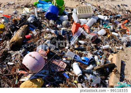 Marine debris washed ashore on a beautiful crystal beach 99118335